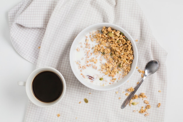 Photo tasse à thé; bol de repas d'avoine; cuillère sur la nappe