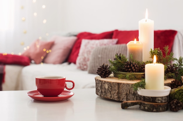 Tasse de thé avec des bougies allumées sur tableau blanc