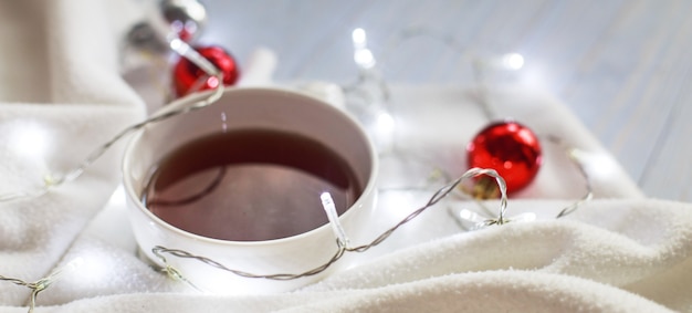 Tasse de thé ou de café guirlande de couverture blanche tricotée et boules de décoration de Noël