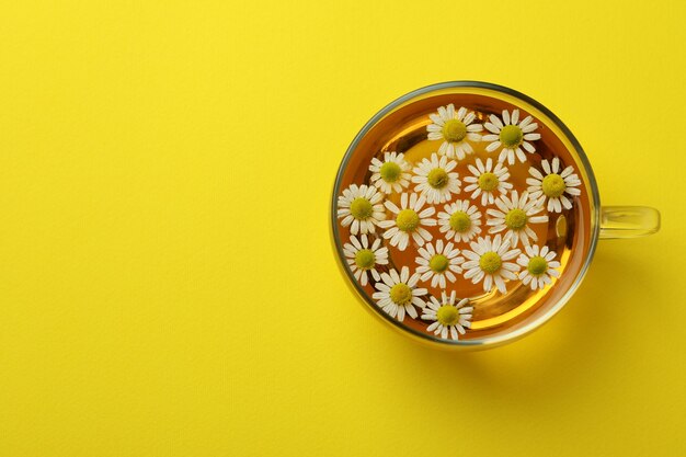 Tasse de thé à la camomille sur jaune