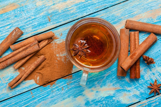 Tasse de thé à la cannelle chaude aromatique sur une table en bois