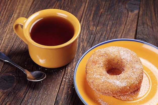 Tasse de thé chaud et beignet sucré