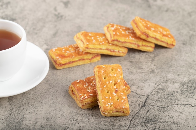 Tasse de thé chaud avec des biscuits croustillants aux graines de sésame.