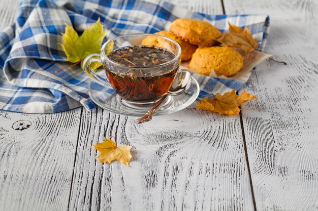 Tasse de thé chaud et feuilles d'automne