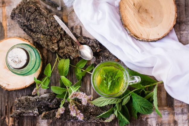 Une tasse de thé chaud à la menthe sur une table en bois, vue de dessus