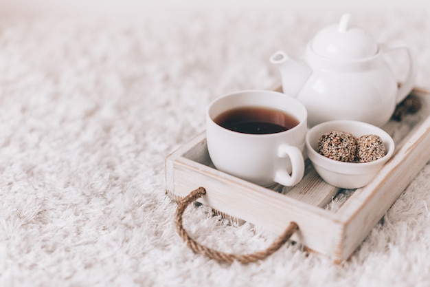 Tasse de thé chaud et théière sur un plateau de service