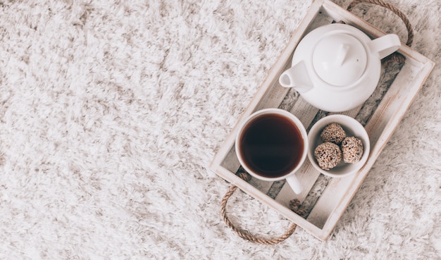 Tasse de thé chaud et théière sur un plateau de service