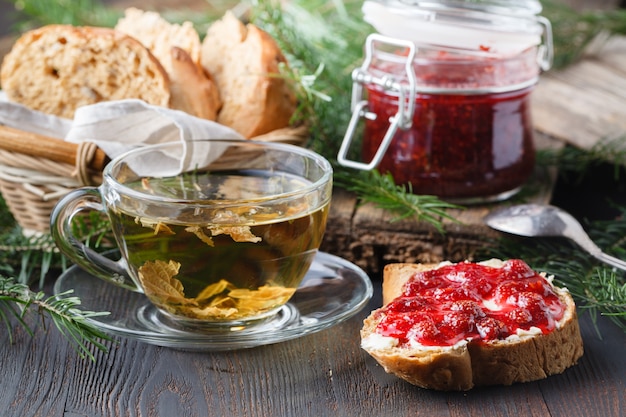 Tasse de thé avec de la confiture de baies sur une vieille table en bois