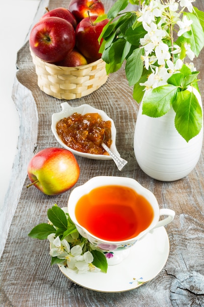 Tasse de thé et confiture de pomme sur une table en bois rustique