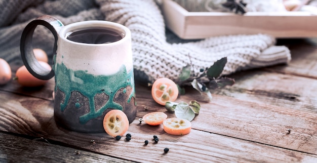 Tasse de thé confortable avec pull sur table en bois