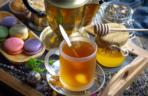 Photo une tasse de thé avec une cuillère dedans et une tasse de thé sur une petite assiette.