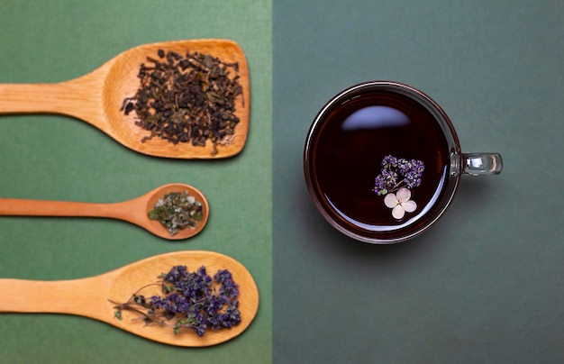 tasse de thé et cuillères en bois avec plantes sèches. Vue d'en-haut