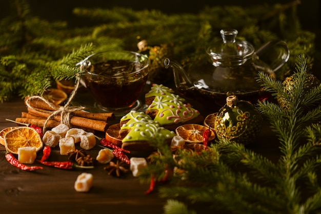 Tasse à thé avec des décorations, des biscuits au pain d'épice et des oranges pour Noël