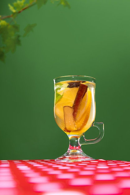 Tasse à thé avec une délicieuse tisane aux agrumes citrons gingembre et menthe isolés sur fond vert