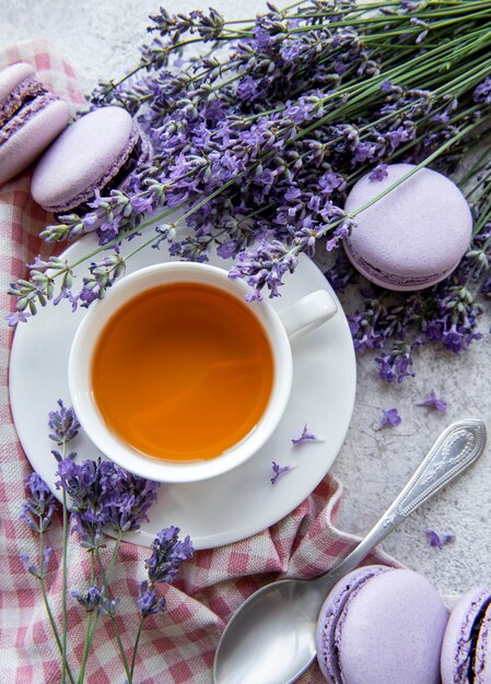 Tasse de thé avec dessert macaron à la lavande et fleurs de lavande fraîche