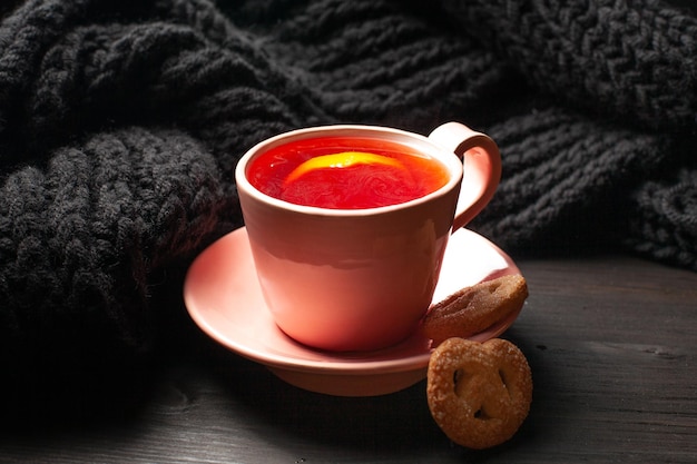 Photo une tasse de thé avec du citron et des biscuits sur fond sombre