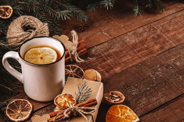 Une tasse de thé avec du citron et des matériaux écologiques pour emballer les cadeaux du nouvel an