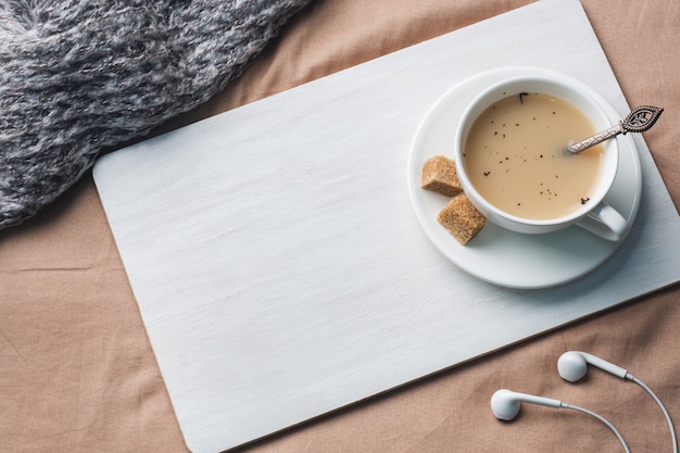 Tasse de thé avec du lait, du sucre d&#39;anis brun et un bloc-notes.