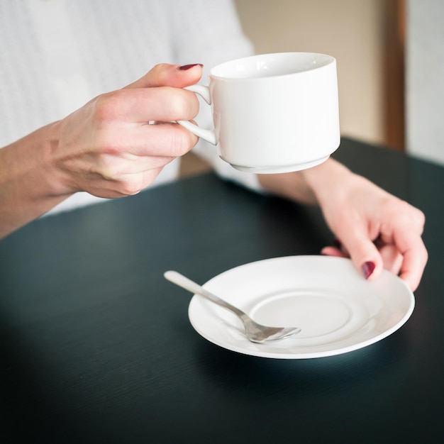 Photo tasse de thé du matin entre les mains d'une jeune femme