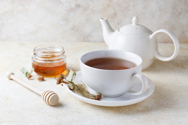 Tasse de thé avec du miel et une théière