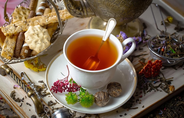 Une tasse de thé est posée sur une assiette à côté d'une tasse de thé.