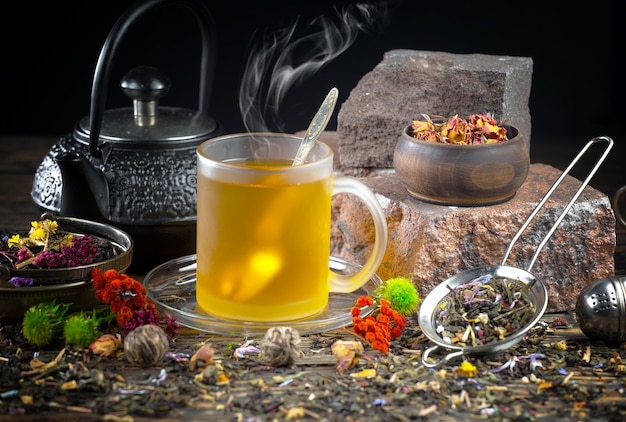 Une tasse de thé est posée sur une table à côté d'un pot de fleurs.