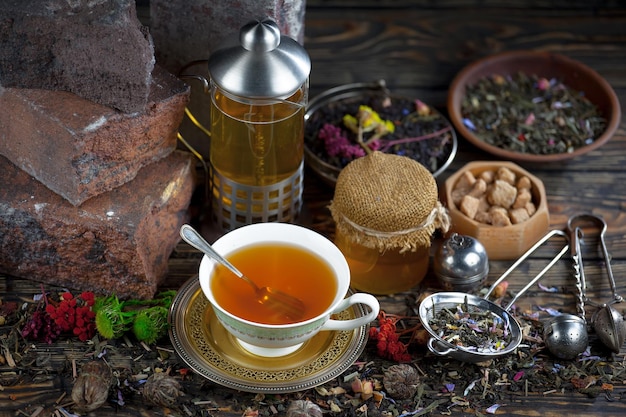 Une tasse de thé est posée sur une table à côté d'un pot de thé.