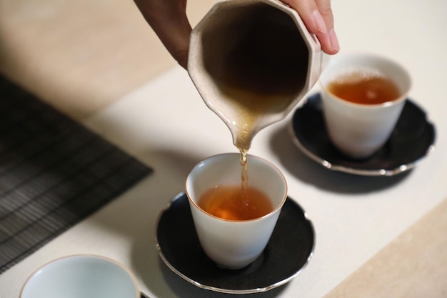 Une tasse de thé est versée dans une tasse.