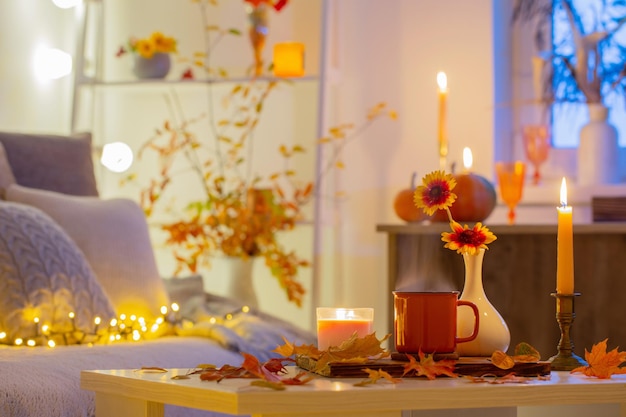 Tasse de thé et feuilles d'automne dans un intérieur confortable