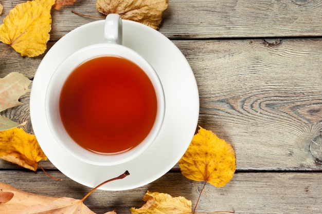 Tasse de thé et feuilles d'automne sur la table