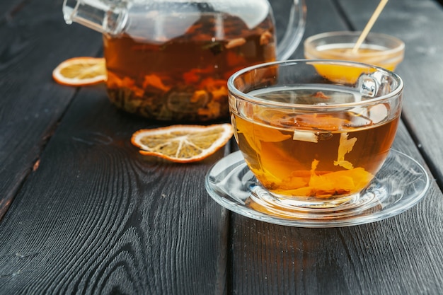 Tasse de thé et feuilles de thé sur table en bois