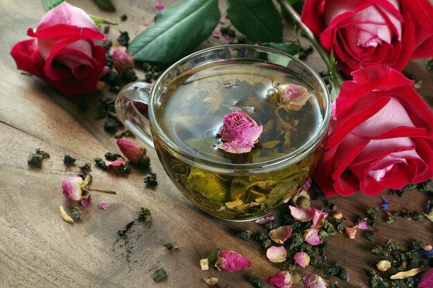 Une tasse de thé avec des fleurs et des feuilles