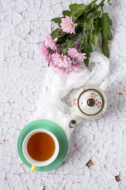 Tasse de thé avec fond floral avec des tulipes et des pâquerettes rouges et blanches