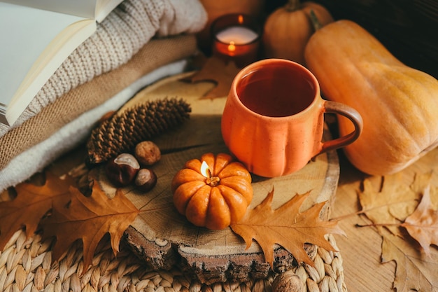 Une tasse de thé en forme de citrouille et un décor d'automne sur la photo esthétique du rebord de la fenêtre