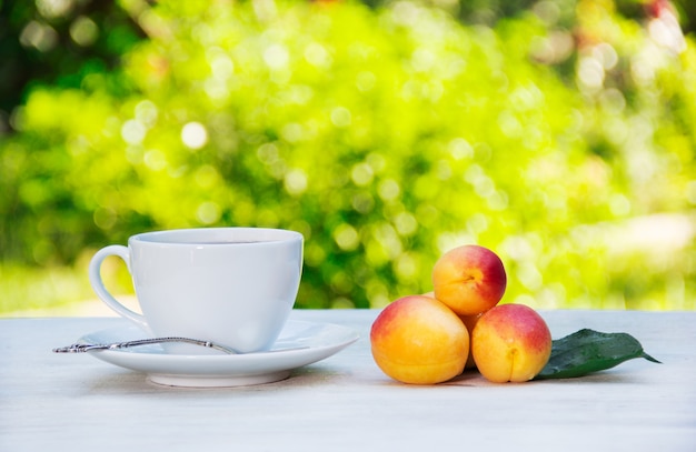 Tasse de thé et de fruits frais dans le jardin d'été