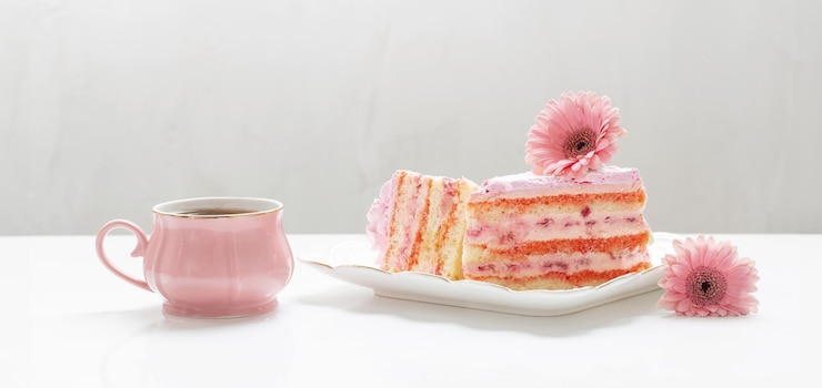 Photo une tasse de thé avec un gâteau rose sur une table blanche.