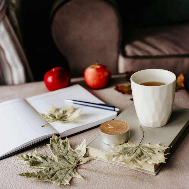 Tasse de thé avec un livre à l&#39;intérieur avec une feuille d&#39;automne