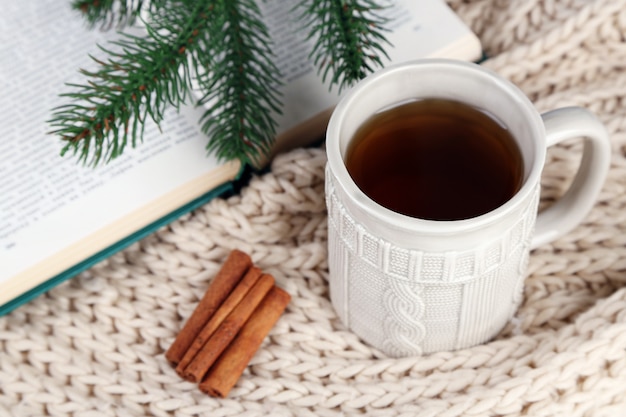 Tasse de thé avec livre sur table close-up