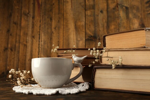 Tasse de thé avec des livres sur fond de bois