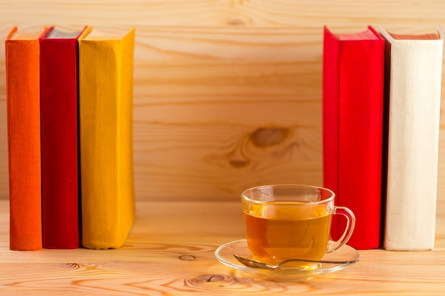 Tasse de thé et de livres sur fond de bois