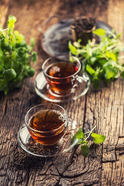 Une tasse de thé mélisse aux herbes sur table en bois.