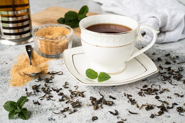 Tasse de thé à la menthe et au citron isolé sur fond noir.