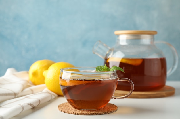 Tasse de thé, menthe, citron, théière et serviette sur blanc, copie espace