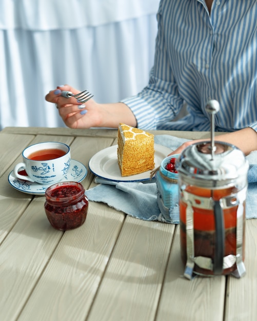 Une tasse de thé et un morceau de gâteau au café