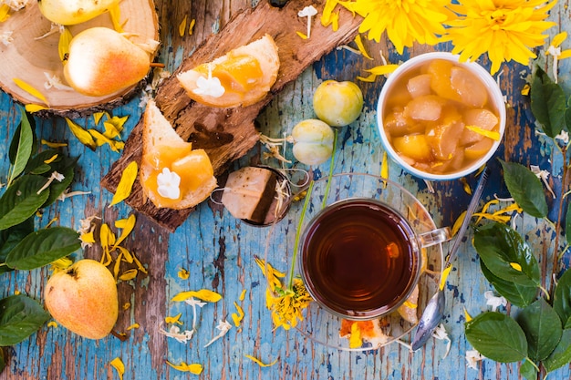 Une tasse de thé noir et de confiture de poires dans un bol et sur un morceau de pain, vue de dessus