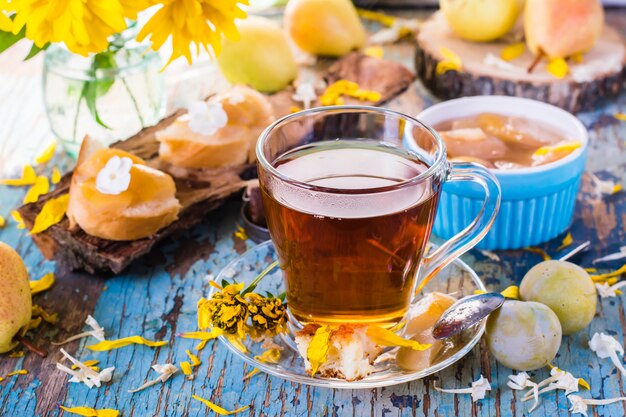 Une tasse de thé noir et de confiture de poires dans un bol