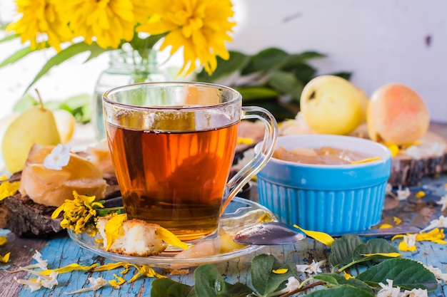 Une tasse de thé noir et de confiture de poires dans un bol