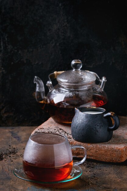 Une tasse de thé noir avec du lait.