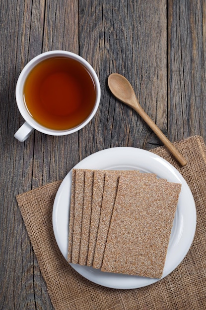 Tasse de thé et pain croustillant pour les aliments diététiques sur une vue de dessus de table en bois rustique