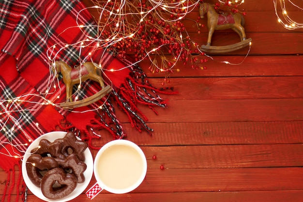 Une tasse de thé, pain d'épice de Noël sur une table en bois rouge